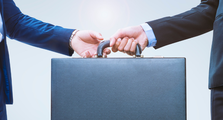 Two businessmen transferring a brief case