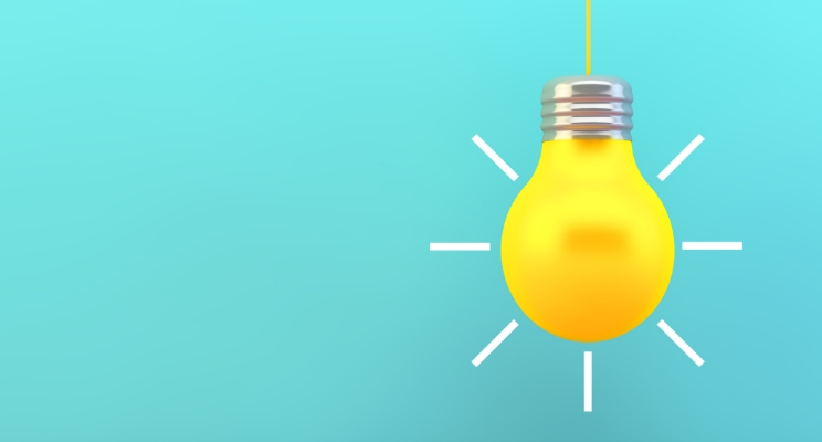 illuminated cartoon lightbulb against blue background