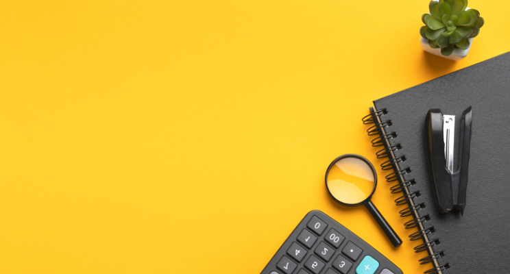 top view of office supplies against yellow background