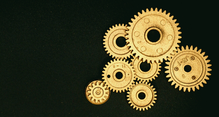 several golden gears against black background
