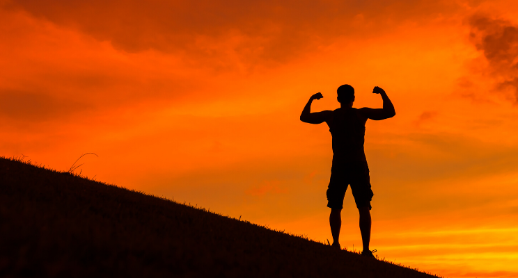 silhouette of man at dusk on a hill posing