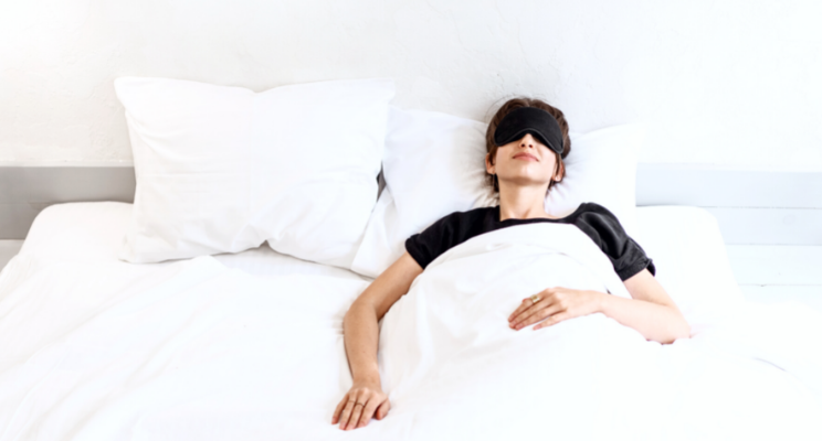 woman in bed with black eye mask