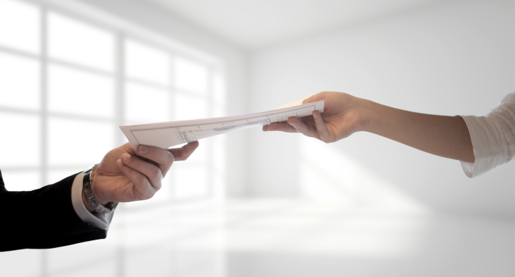 two hands exchanging paperwork