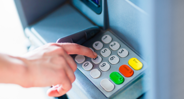a finger hovering over the number 3 of an atm machine keypad