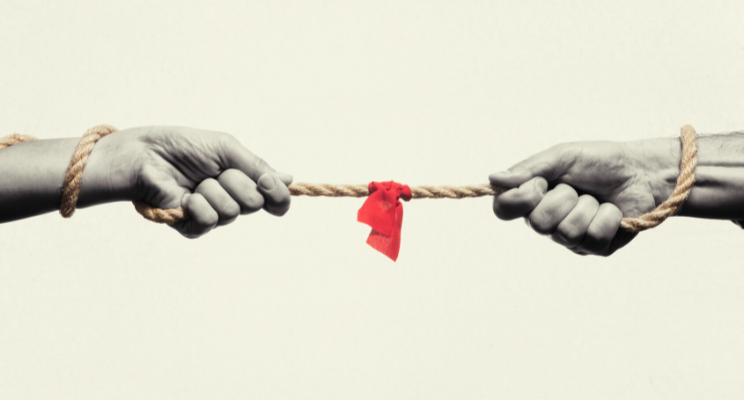 two hands intertwined with rope and a red flag