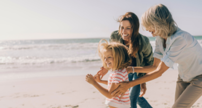 multi-generational women playing on the beach at sunrise